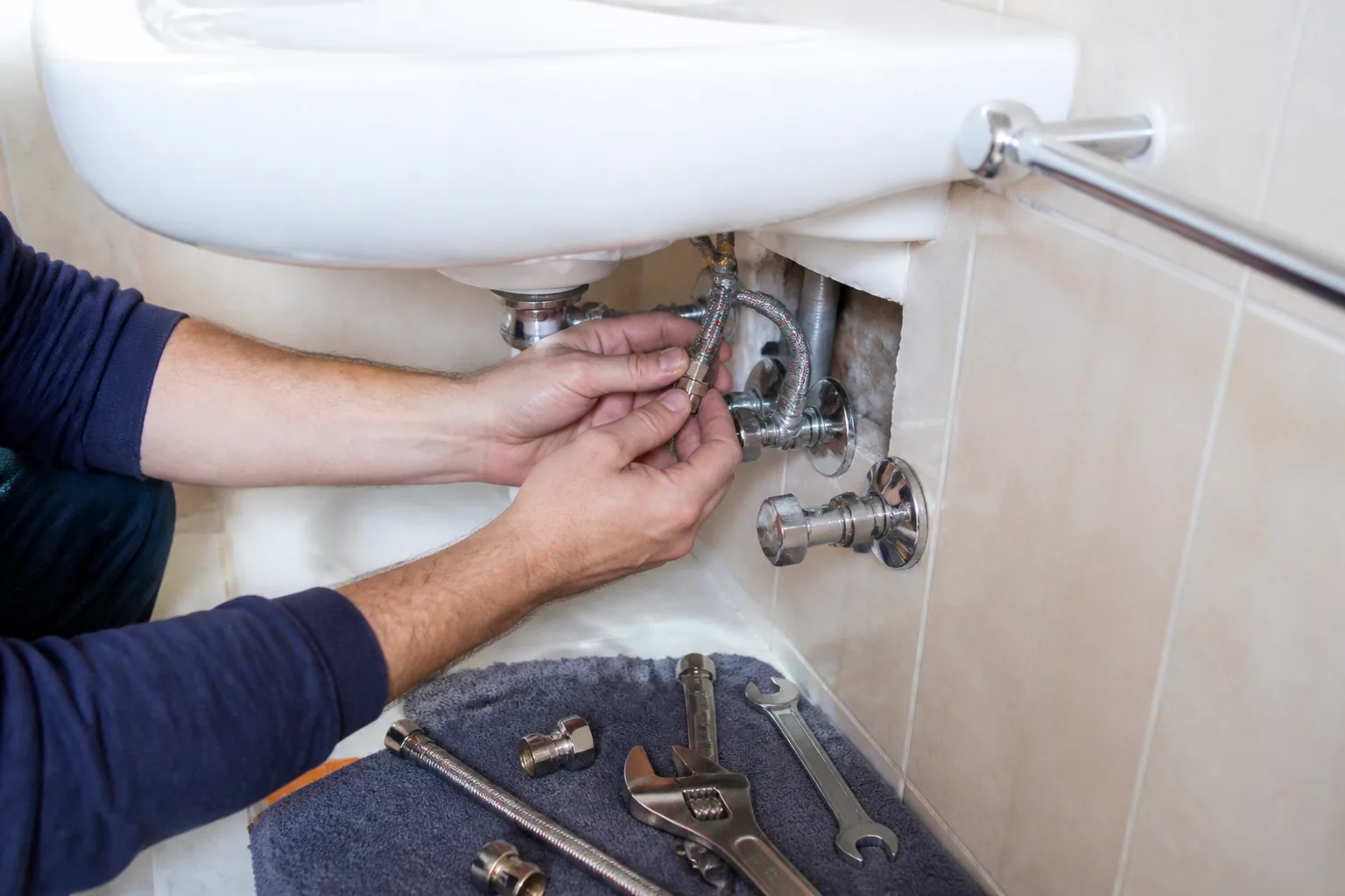 Conexión de latiguillos y llaves de paso bajo un lavabo